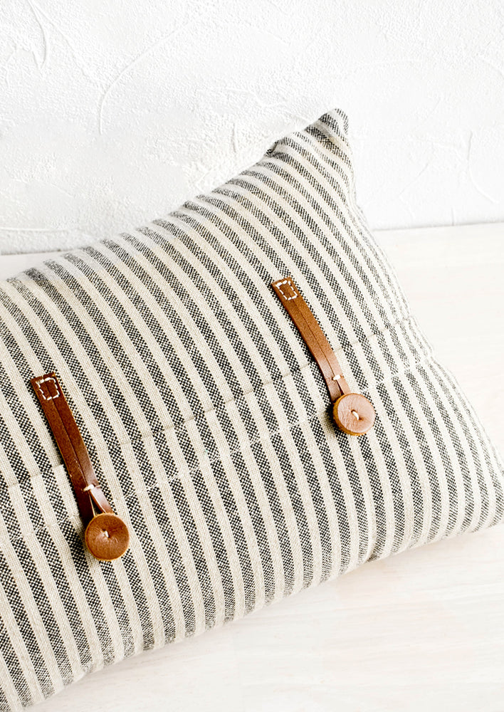 Striped cotton pillow in black and beige with decorative leather button detailing