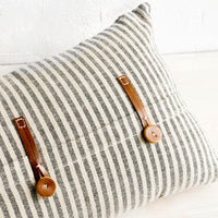 1: Striped cotton pillow in black and beige with decorative leather button detailing