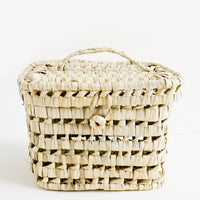 1: A square-shaped, lidded basket made from woven natural palm leaf.