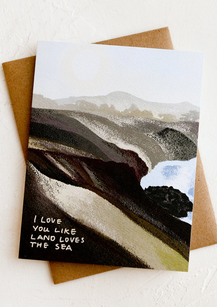 An illustrated card with landscape image, text at corner reads "I love you like the land loves the sea".