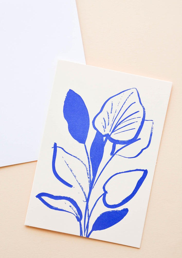 White notecard with cobalt blue lily plant, with white envelope. 