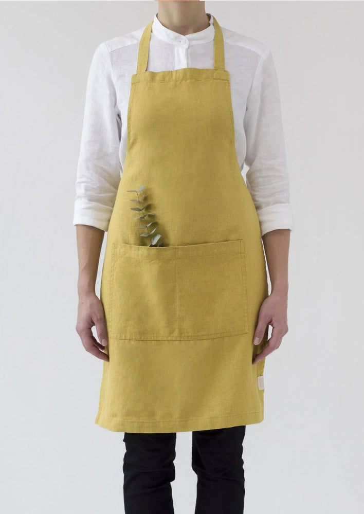 A women wearing a linen apron in chartreuse color.