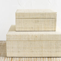 2: Small and large upholstered linen storage boxes.