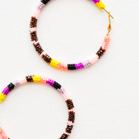 Yellow / Bronze Multi: Hoop earrings with pink, bronze, purple and black glass beads arranged in a circle.