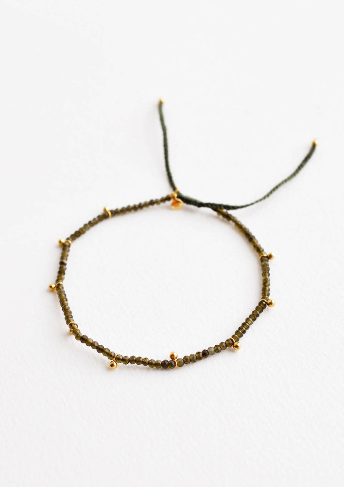 Moss Agate: A bracelet of small green gemstones and evenly spaced gold beads.