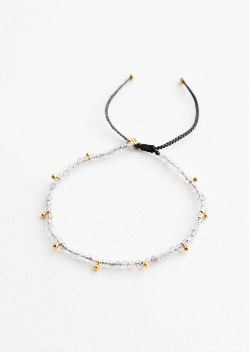 Labradorite: A bracelet of small gray gemstones and evenly spaced gold beads.
