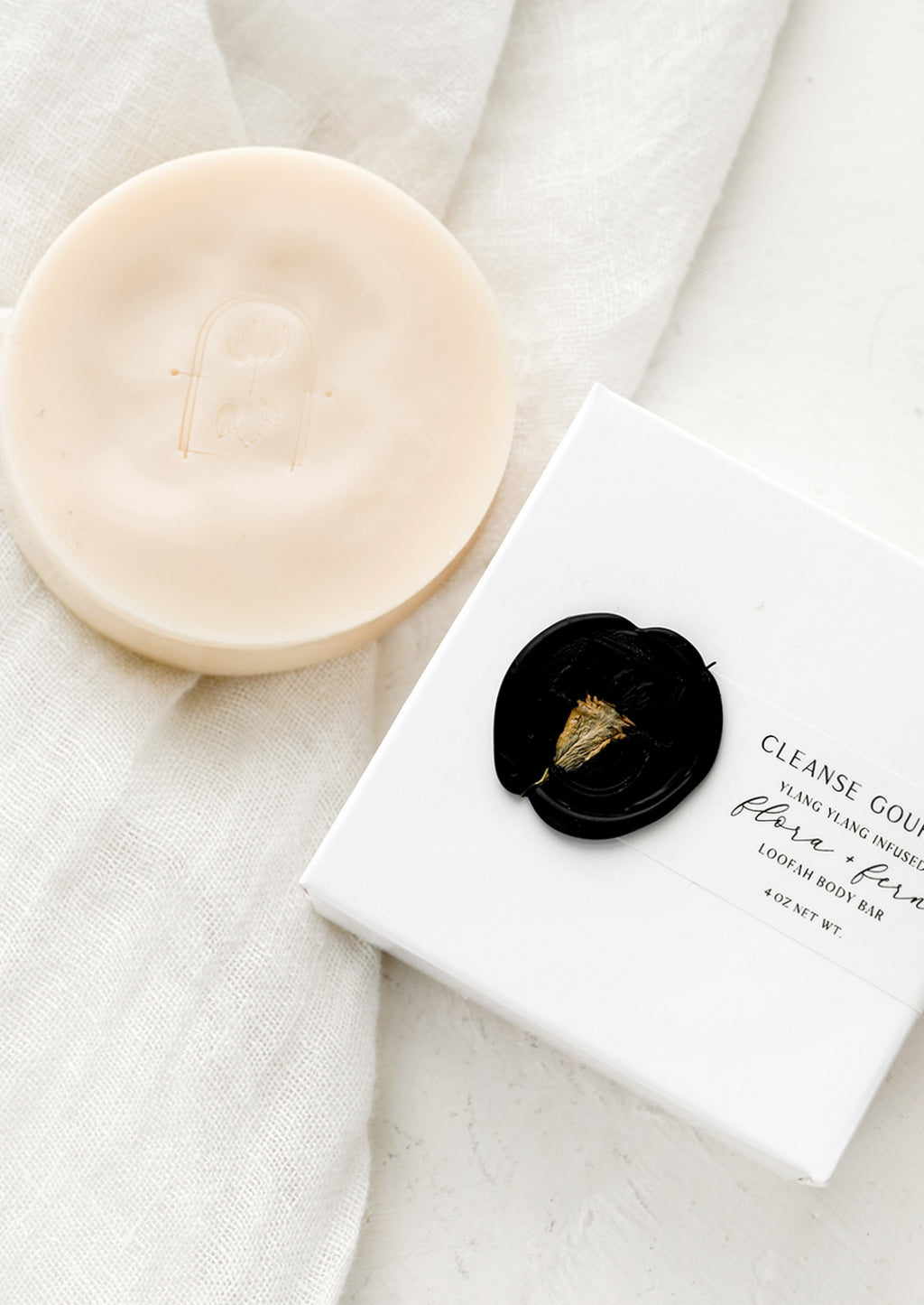 Flora + Fern: A round opaque blush bar soap with wax seal packaging.