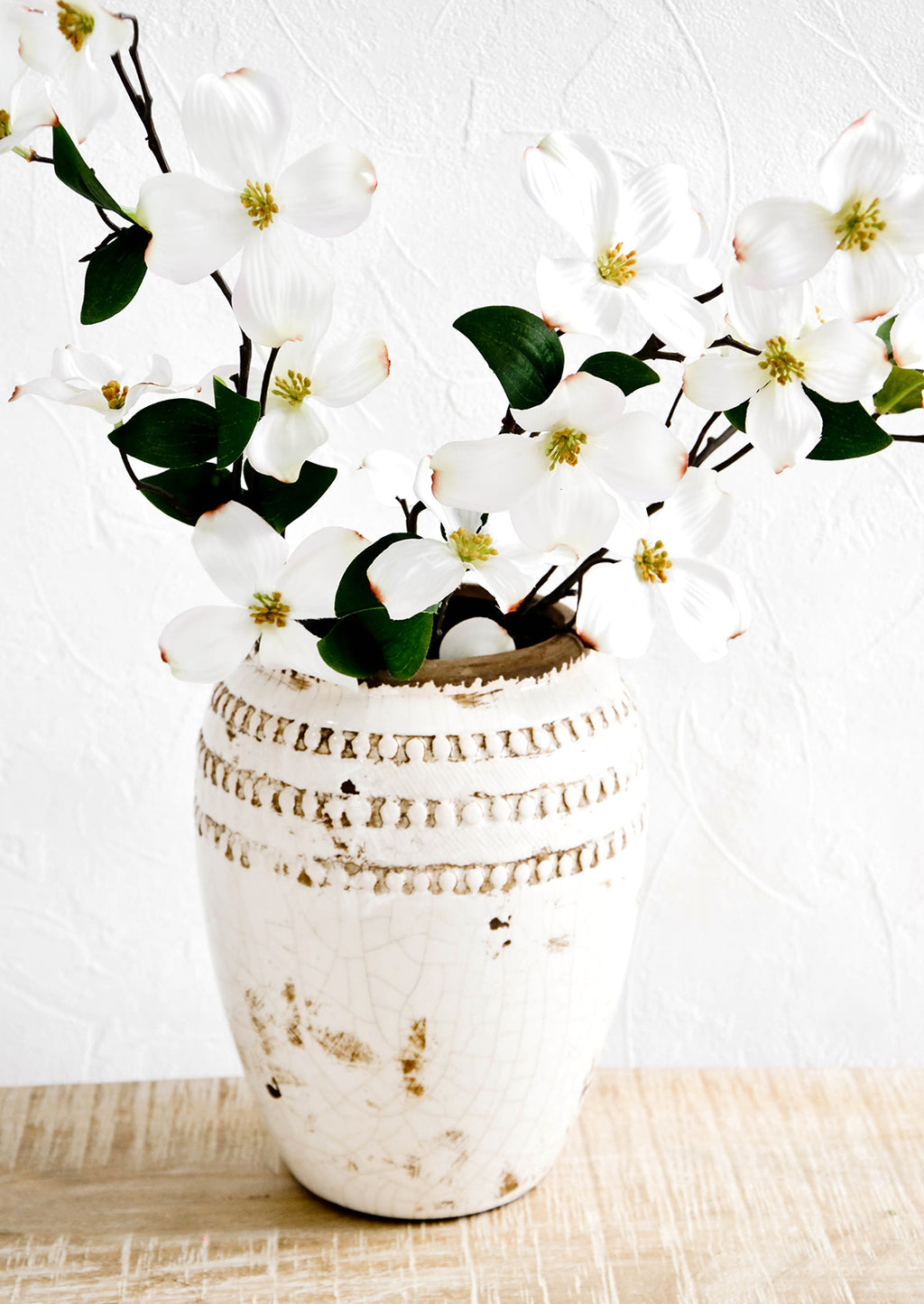 2: Distressed cream and brown urn-shaped vase with magnolia branches