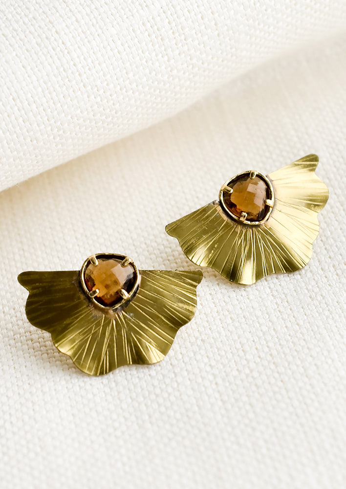 A pair of fan-shaped brass earrings with brown crystal.