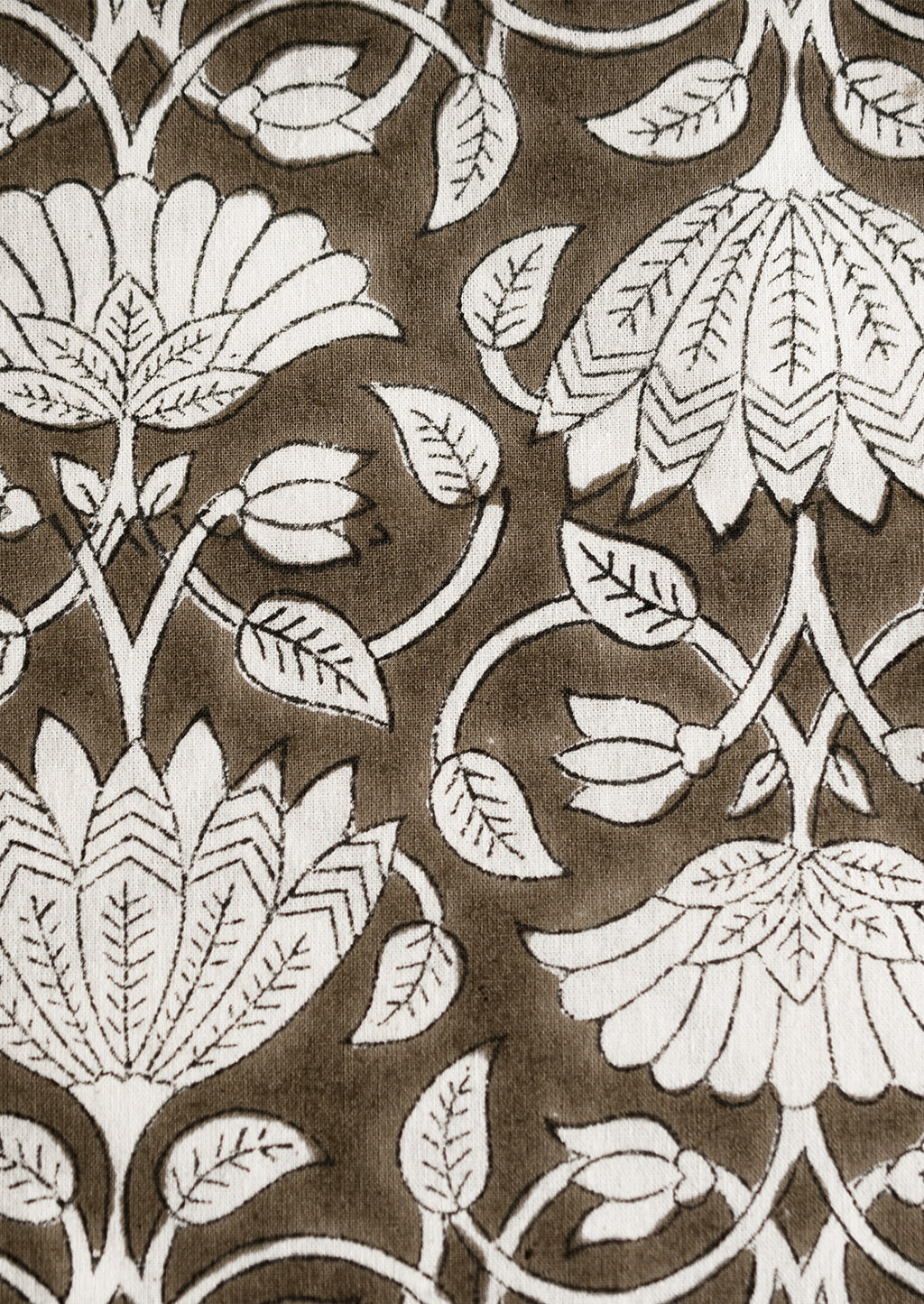 3: A block printed tablecloth with white lotus print on brown background.