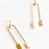 Apricot: Post back gold earrings with curved arc featuring one cream color beaded end and one square gold end.