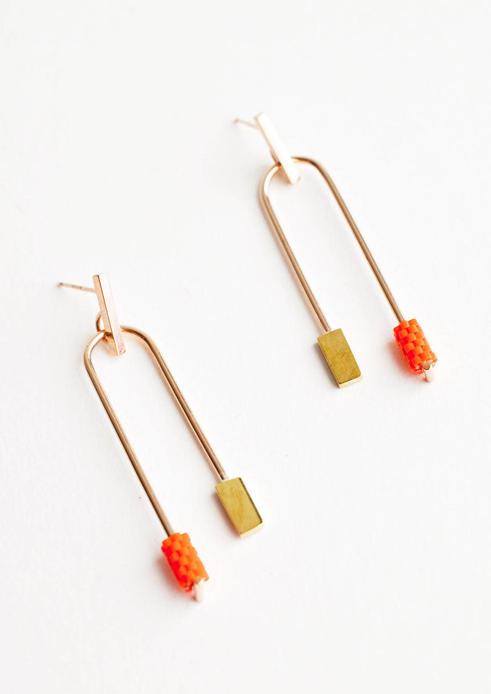 Orange: Post back gold earrings with curved arc featuring one orange beaded end and one square gold end.