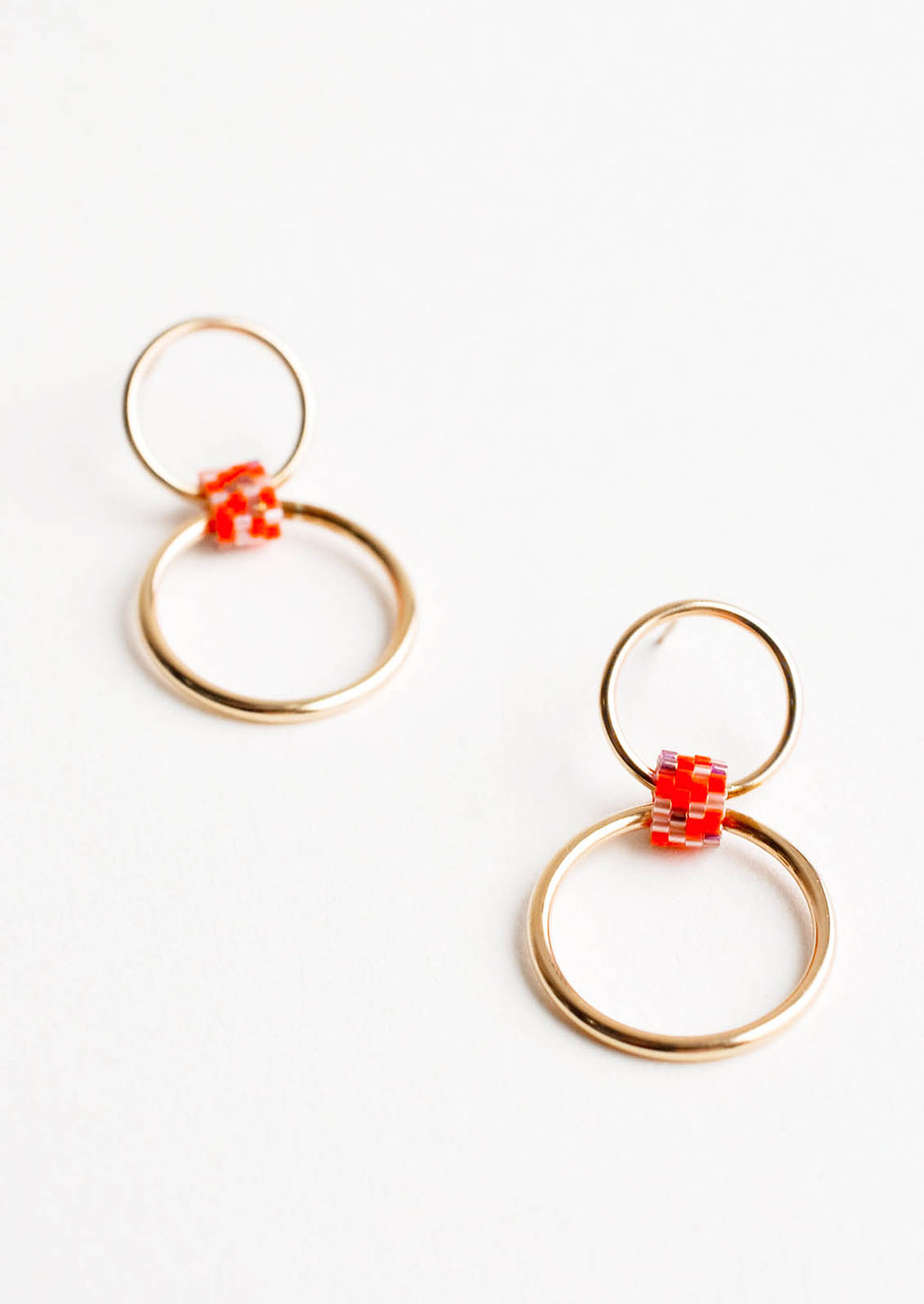 Orange Multi: Post back earrings of one small gold hoop and one larger gold hoop connected by a loop of orange glass beads.