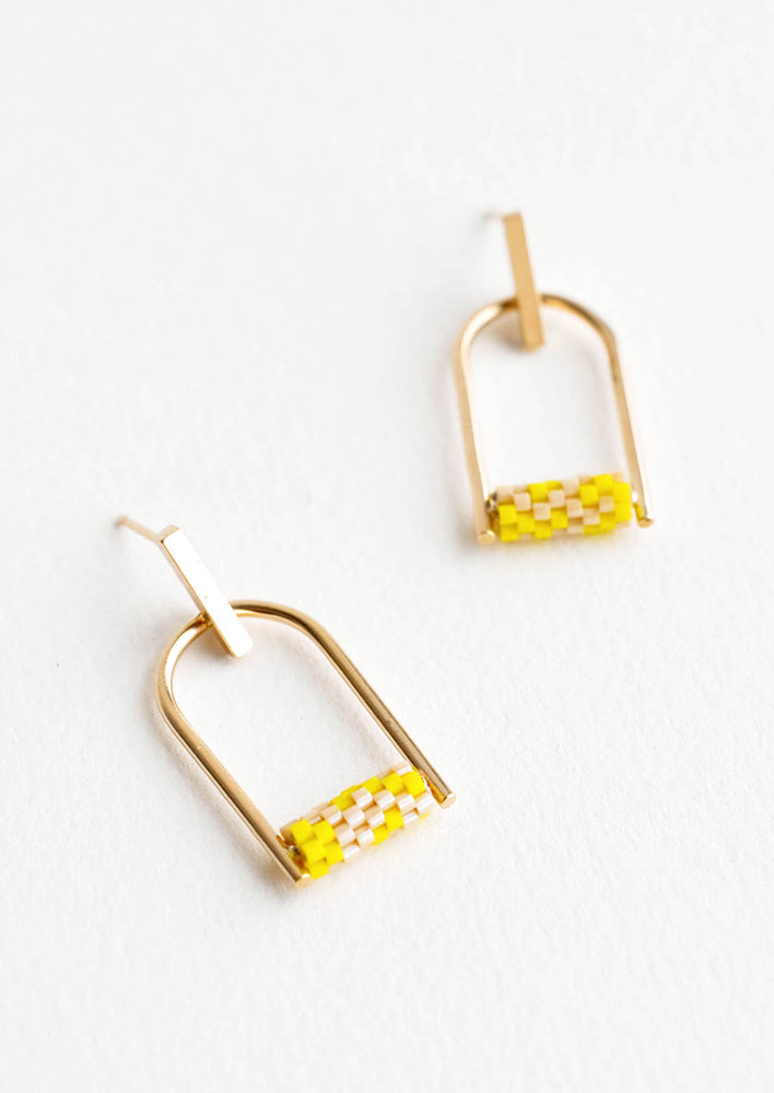 Arced gold post back earrings with yellow beads closing off the arc.