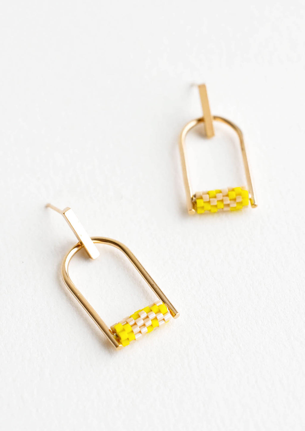 2: Arced gold post back earrings with yellow beads closing off the arc.
