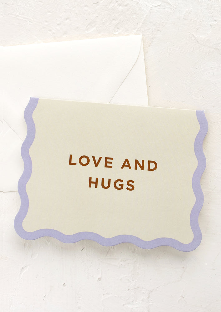 1: A greeting card with wavy edge border and text reading "Love & Hugs".