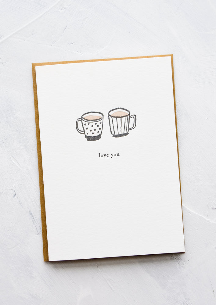 1: A letterpress printed greeting card with an image of two coffee mugs side by side, text below image reads "love you".