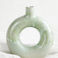 Circular: A ceramic vase in mottled aqua glaze with hollow circle shape.