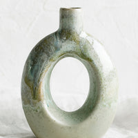 Oval: A ceramic vase in mottled aqua glaze with hollow oval shape.