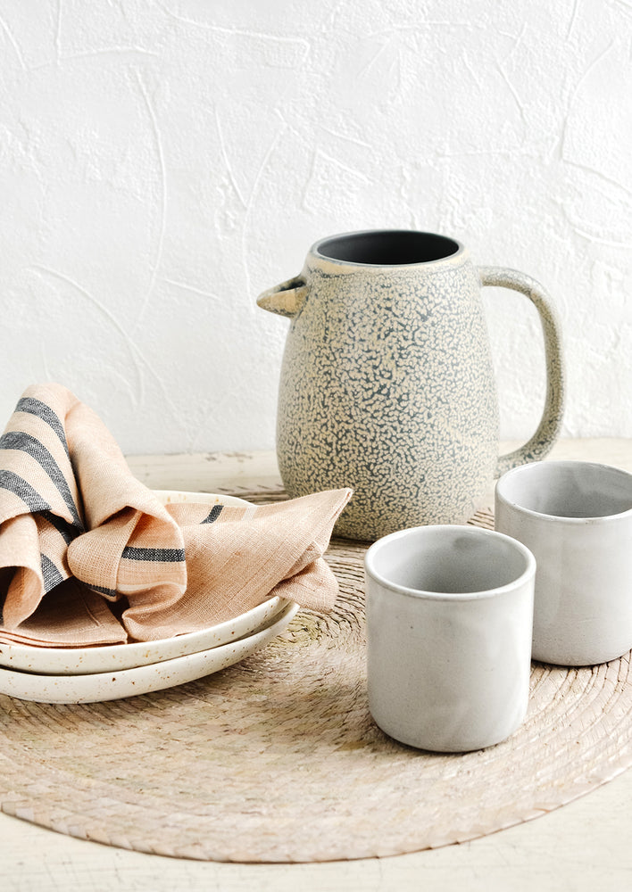 An arrangement of assorted tableware in warm pastel hues.