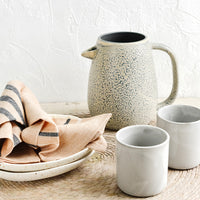 2: An arrangement of assorted tableware in warm pastel hues.