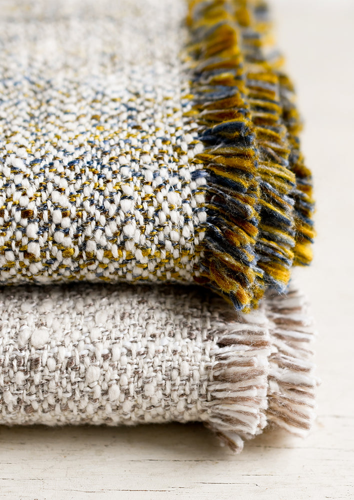 Textured throw blankets with fringe trim.