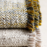 2: Textured throw blankets with fringe trim.
