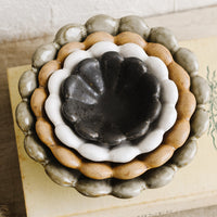 2: Nesting flower shaped ceramic bowls in different colors.