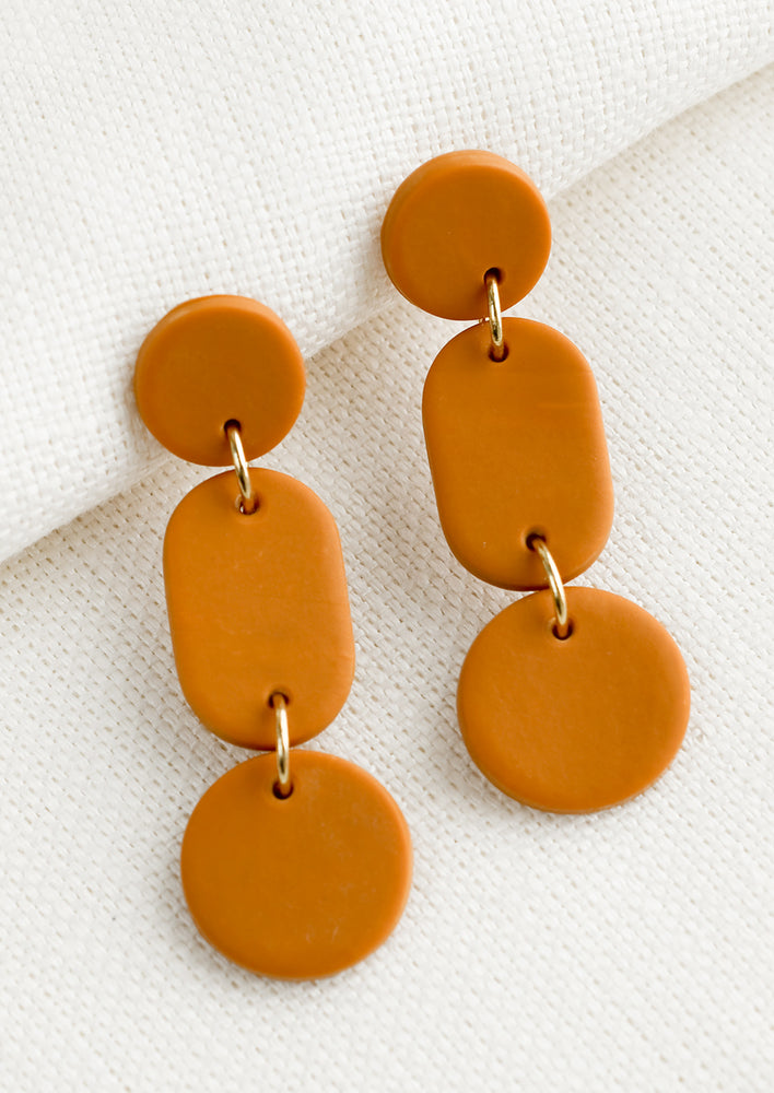 A pair of earrings in three part geometric design in caramel.
