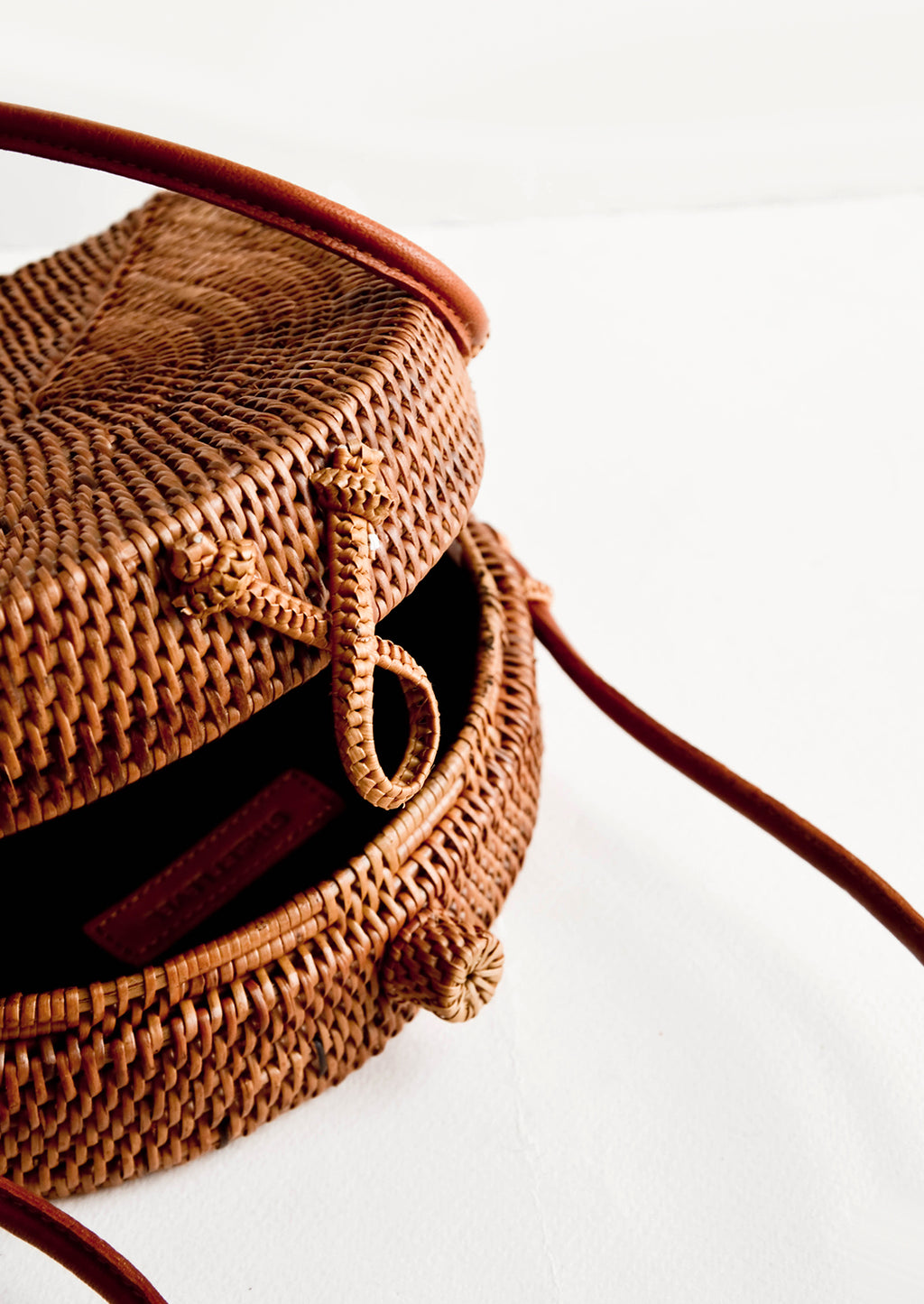 2: Woven clasp closure on smoked rattan handbag.
