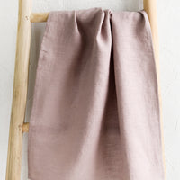 Woodrose: A dusty lilac linen tea towel draped on a wooden ladder.