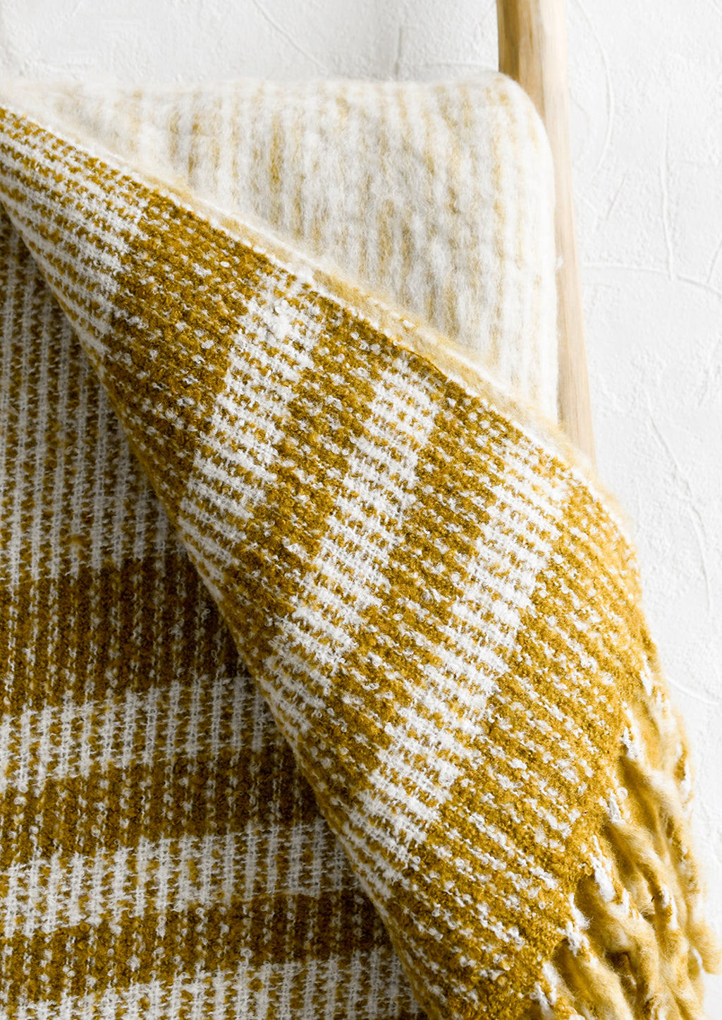 2: A mohair throw blanket in mustard and ivory stripe.
