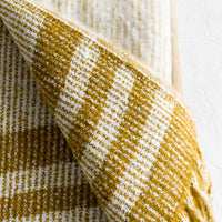2: A mohair throw blanket in mustard and ivory stripe.