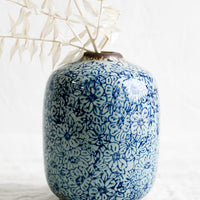 1: A vintage-look ceramic vase with indigo floral pattern.