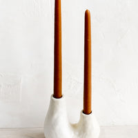 Natural White / Double [$36.00]: A ceramic 2-taper holder in barnacle-like shape with rust colored taper candle.