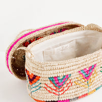 2: Rounded box style straw bag with neon multicolored flower pattern shown with lid off exposing cotton interior lining.