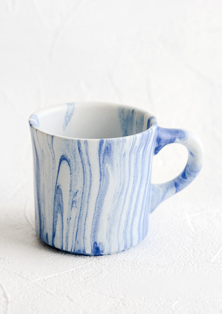 1: A ceramic mug in white with marbleized pattern in blue.