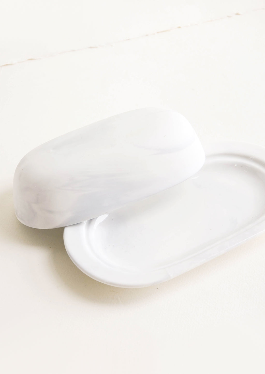 2: Oval shaped butter dish with curved dome lid, matte white ceramic with pale grey marbleized effect 