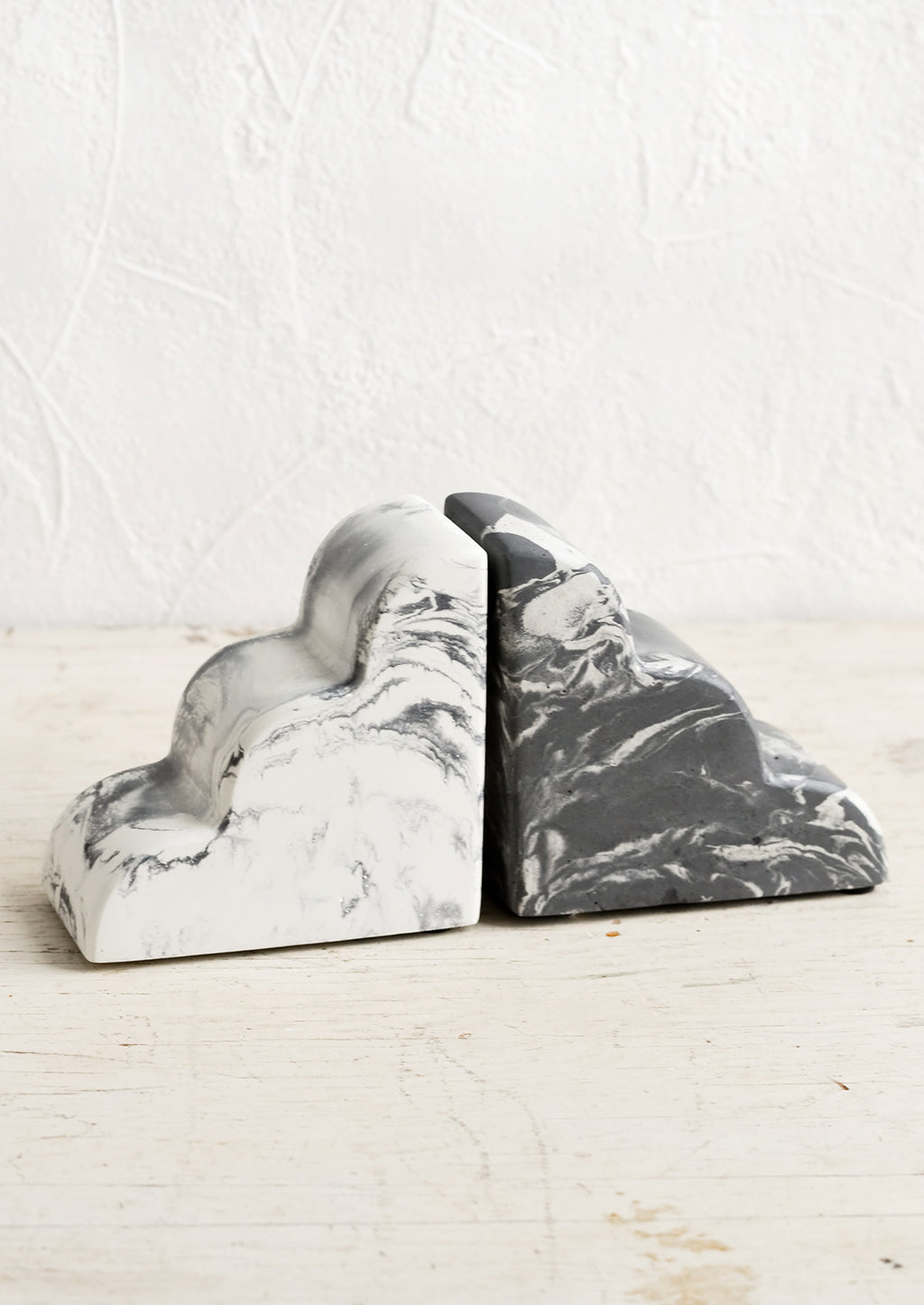 2: A pair of bookends in half-cloud shape in mis-matched, black and white marbleized pattern.