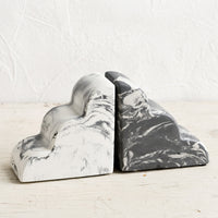2: A pair of bookends in half-cloud shape in mis-matched, black and white marbleized pattern.