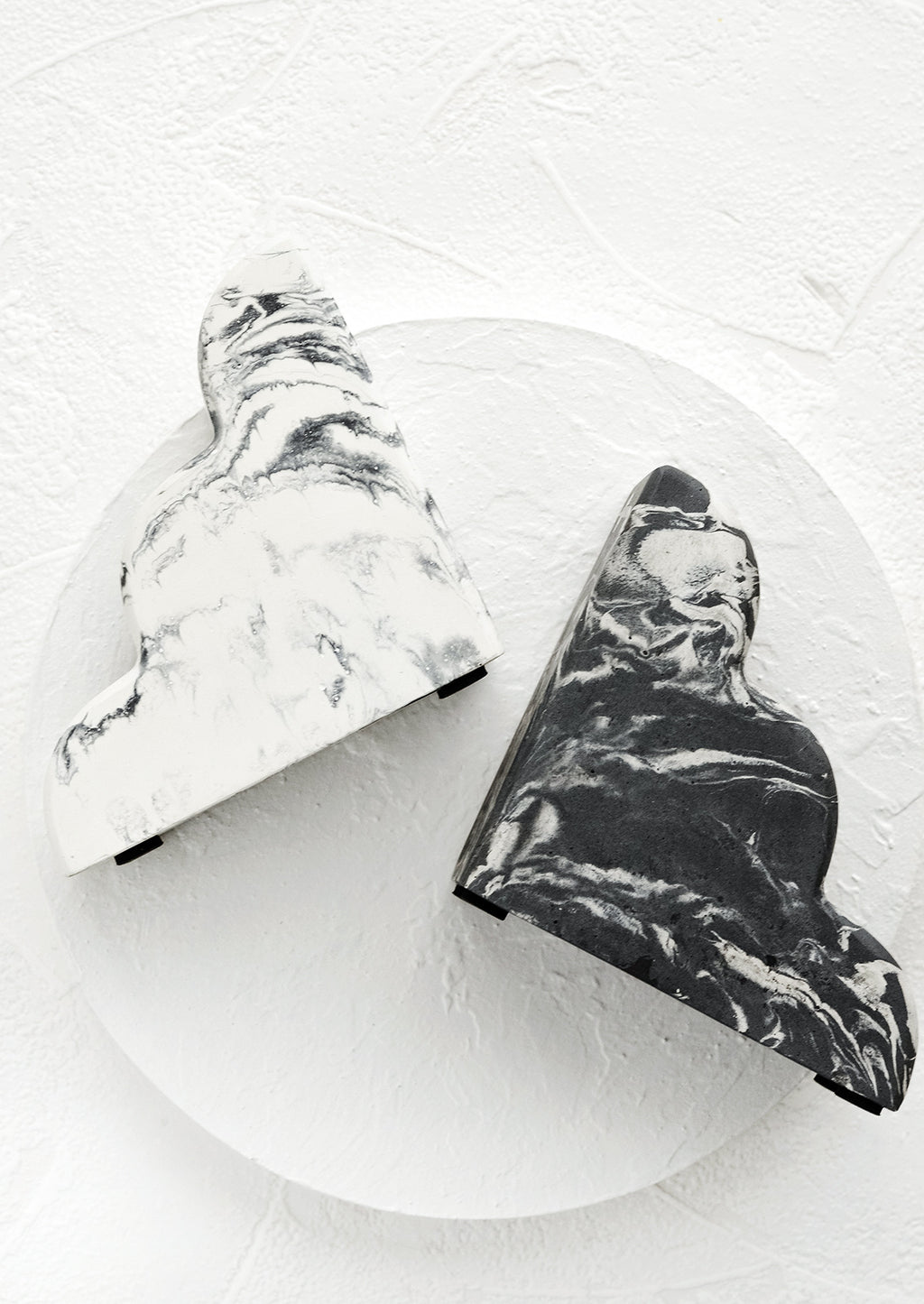 1: A pair of bookends in half-cloud shape in mis-matched, black and white marbleized pattern.