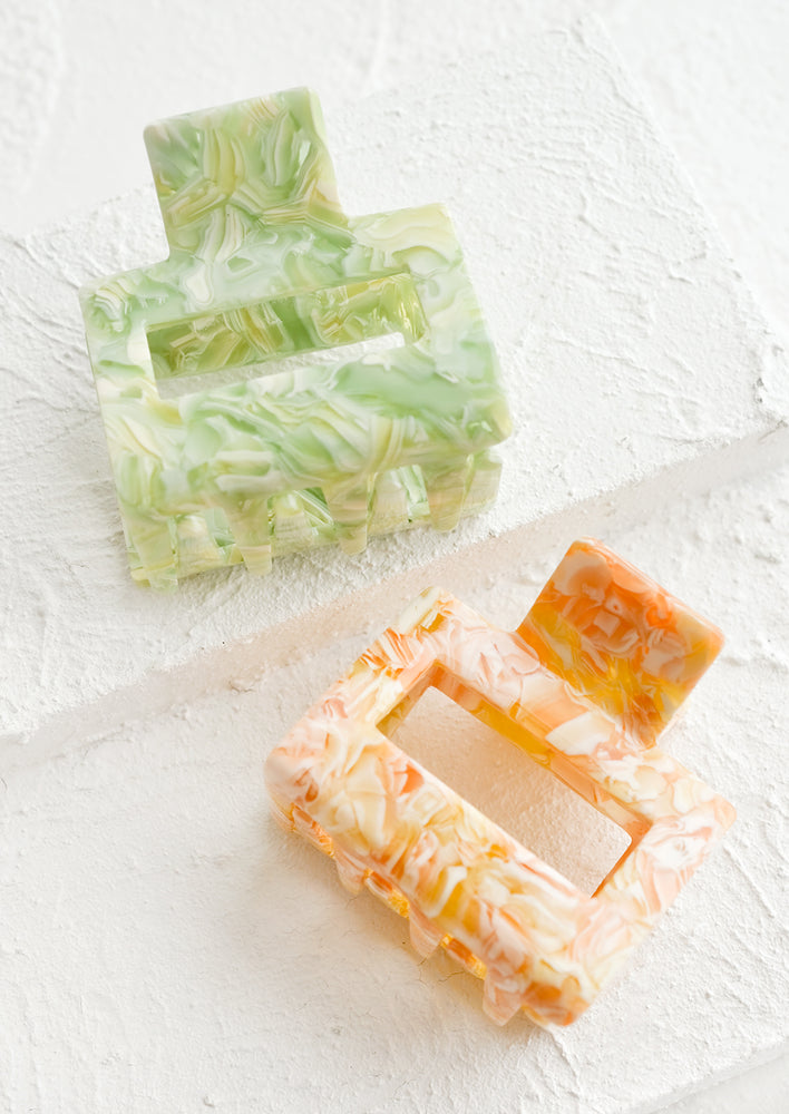 Two marbled hair clips in citrus hues.