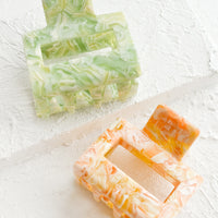 1: Two marbled hair clips in citrus hues.