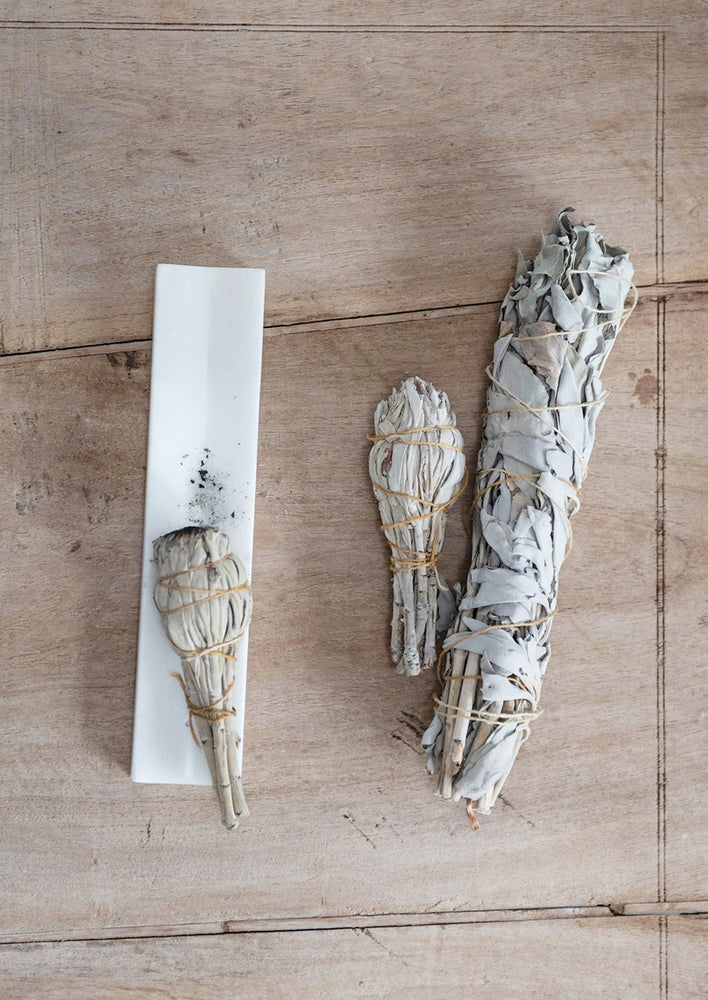 A long solid marble incense burner tray, shown with sage smudge bundles.