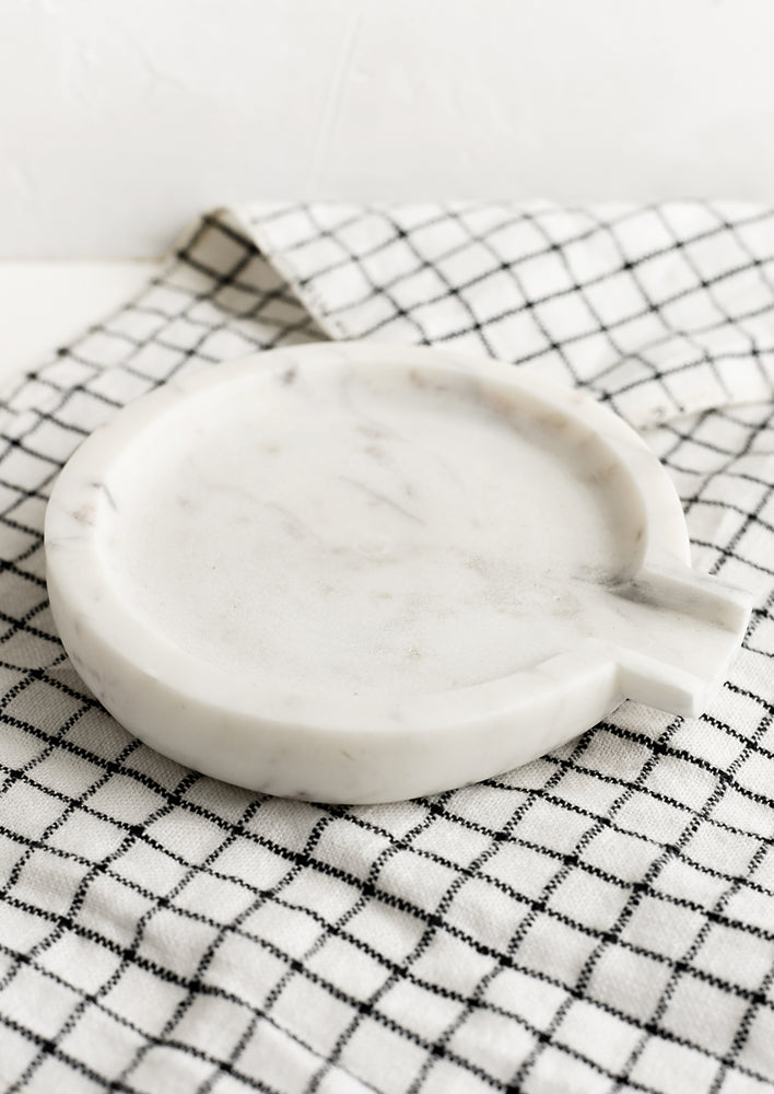 A round white marble spoon rest.