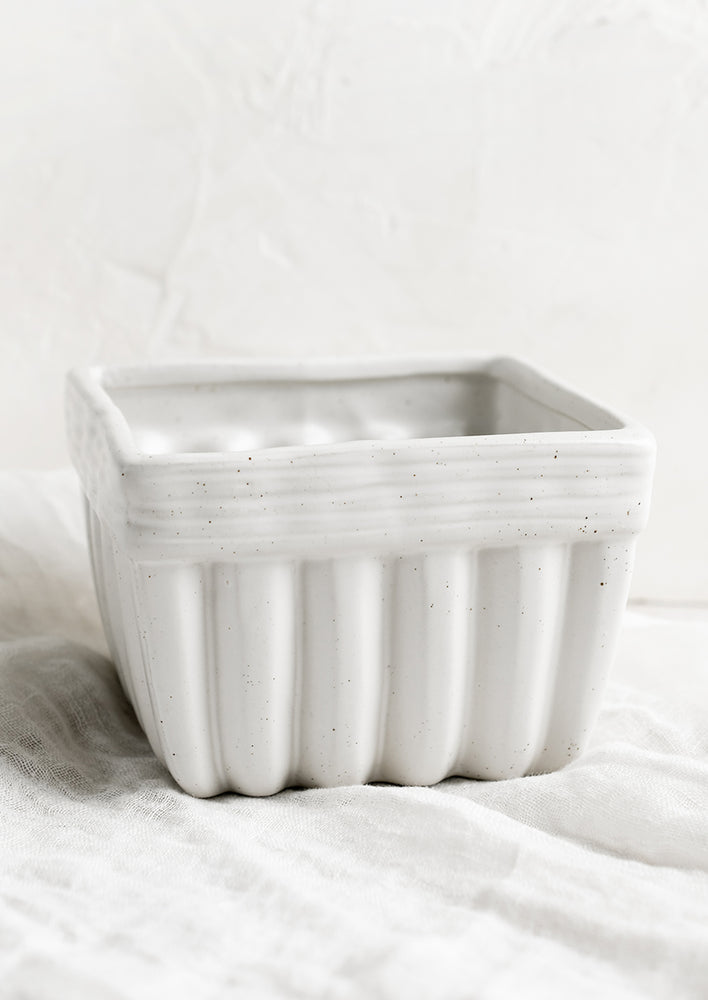 A square ceramic container in the shape of a disposable produce basket.