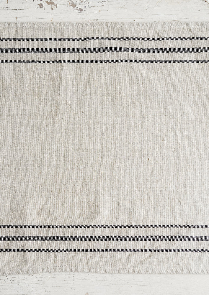 A linen table runner with stripes at sides.