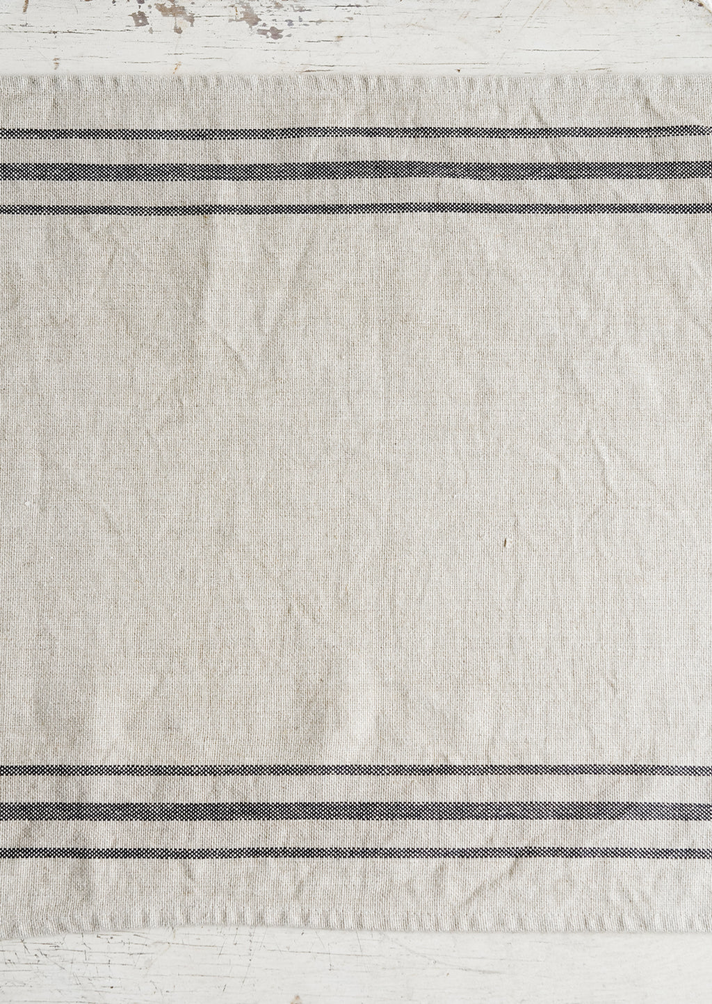 2: A linen table runner with stripes at sides.
