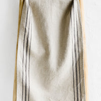1: A linen table runner with stripes at sides.