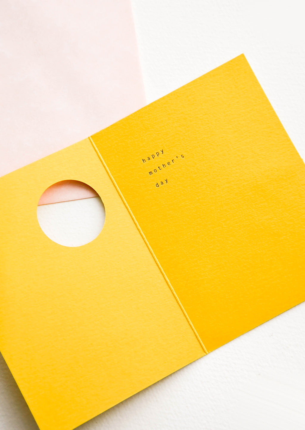 2: Yellow greeting card featuring circular cut out on front, revealing an interior message